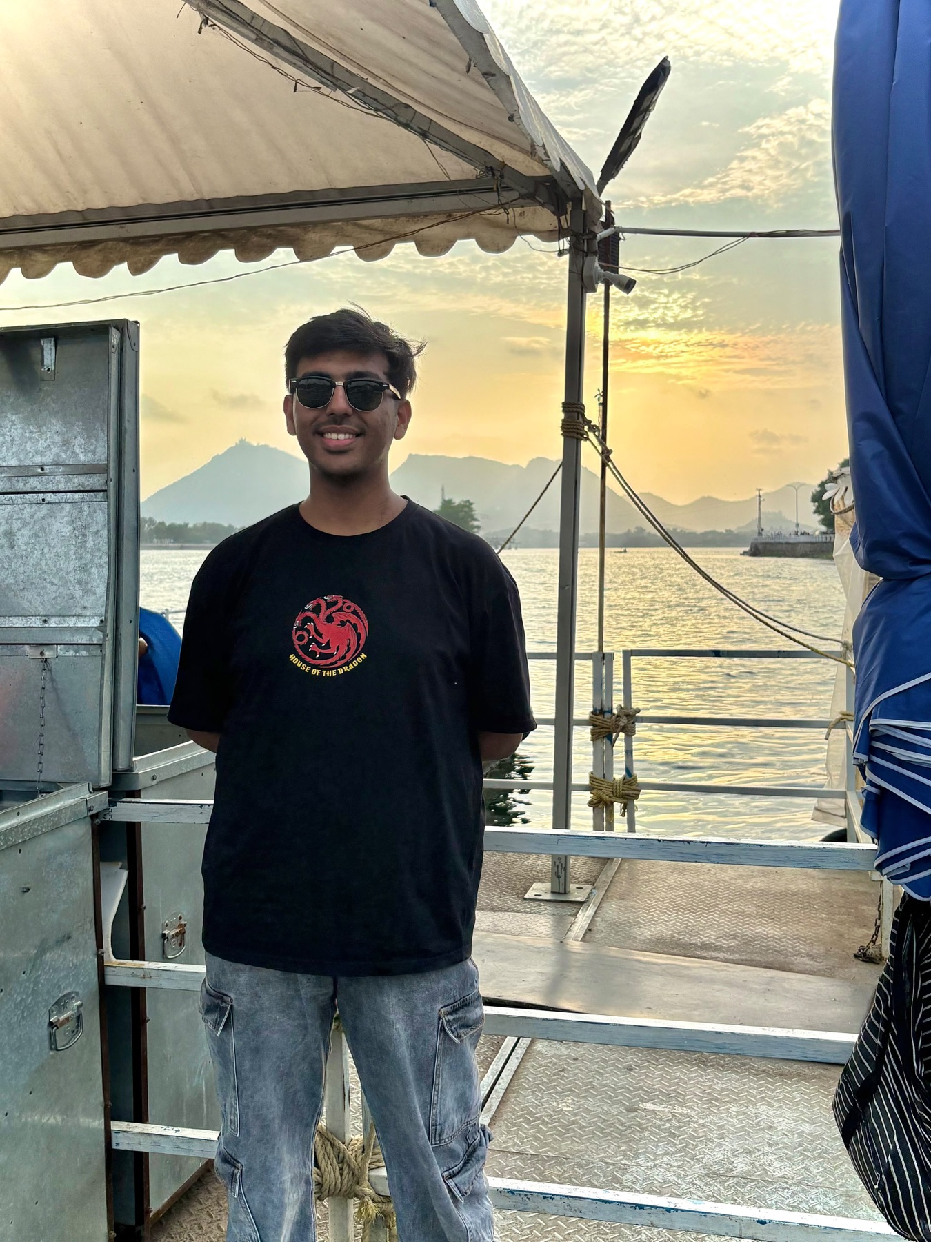Harshit on a boat at sunset